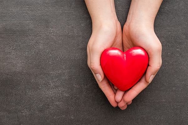 Helping hands holding a heart