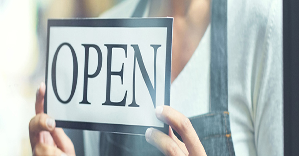 Worker holding an open sign
