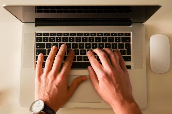 hands typing on laptop keyboard