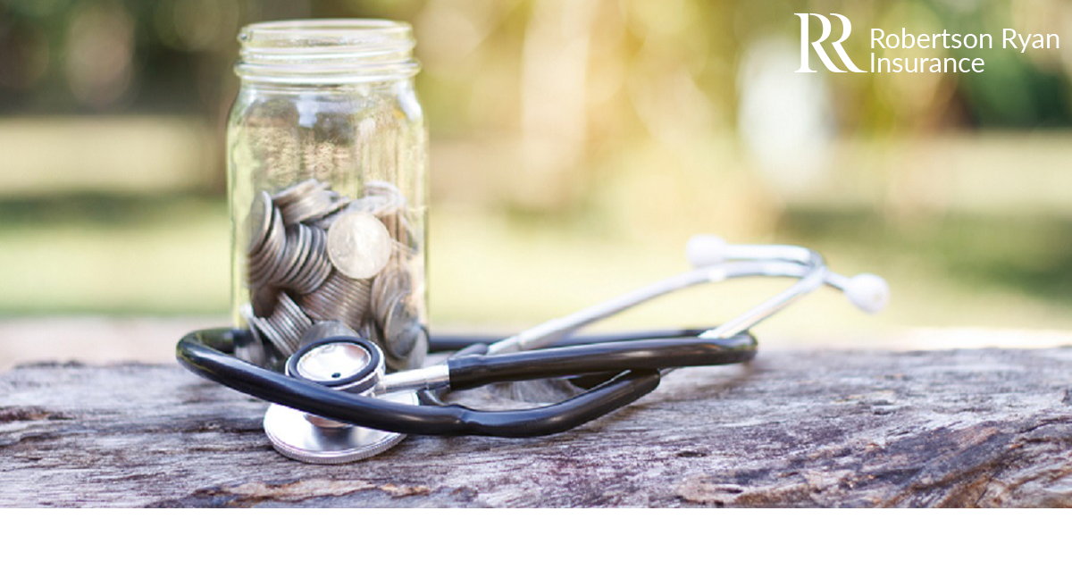 Coin and stethoscope on wooden background